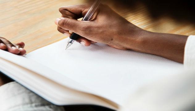 Person Writing in a Notebook